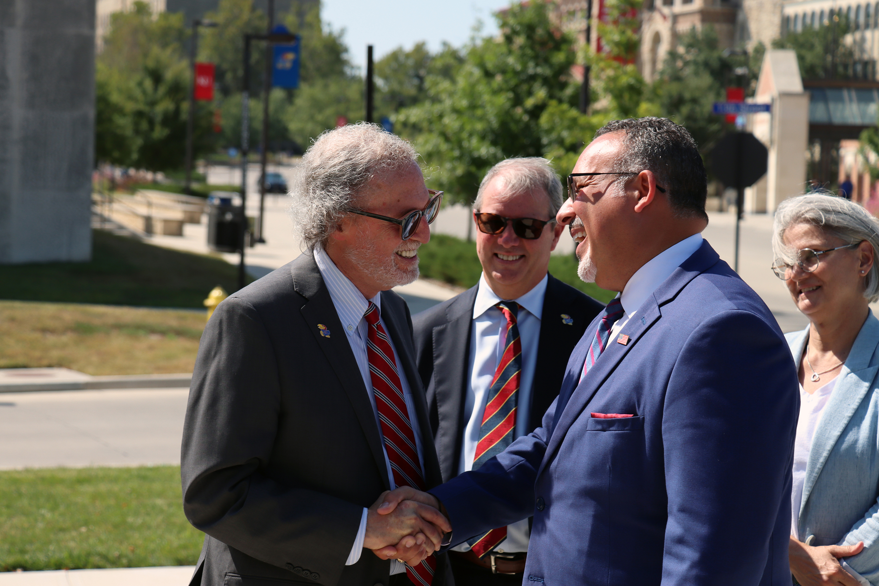 U.S. Secretary of Education Miguel Cardona and School of Education and Human Sciences Dean Rick Ginsberg shake hands, while KU Chancellor Doug Girod and Provost & Executive Vice Chancellor Barbara Bichelmeyer look on. 